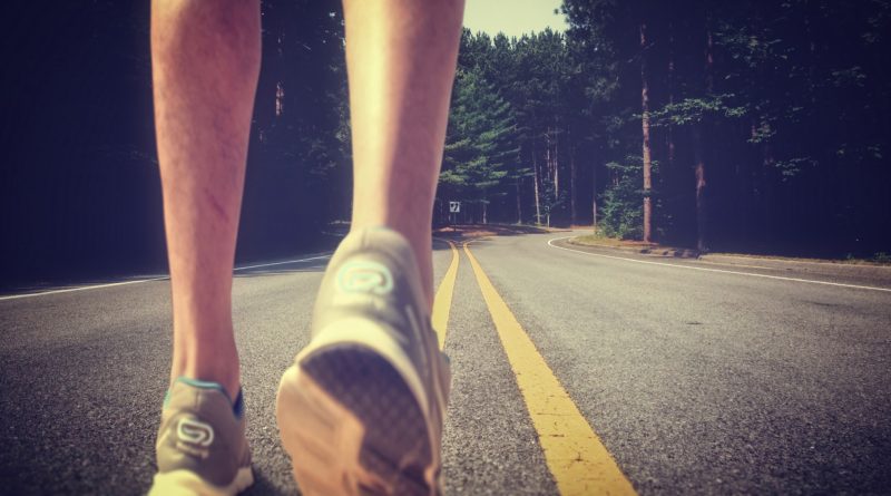 Feet of an athlete running on a deserted road - Training for fitness and healthy lifestyle